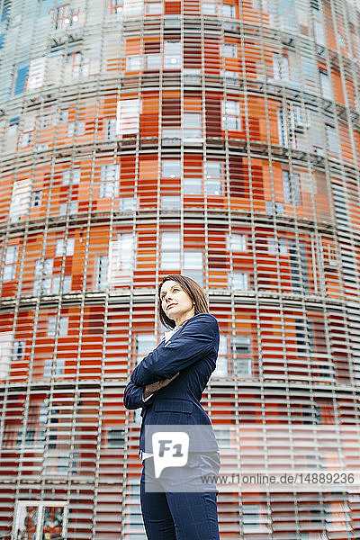 Zuversichtliche Geschäftsfrau steht vor einem Bürogebäude in der Stadt