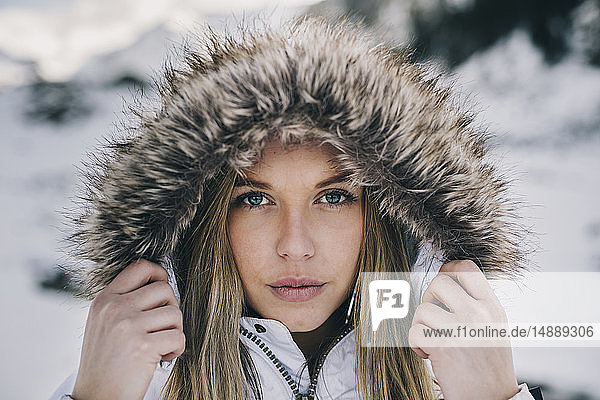 Porträt einer jungen blonden Frau mit Kapuze im Winter