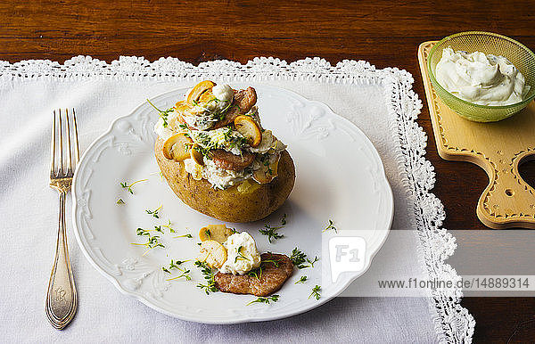 Gebackene Kartoffel mit Quark  Rindfleisch und Champignons auf Teller