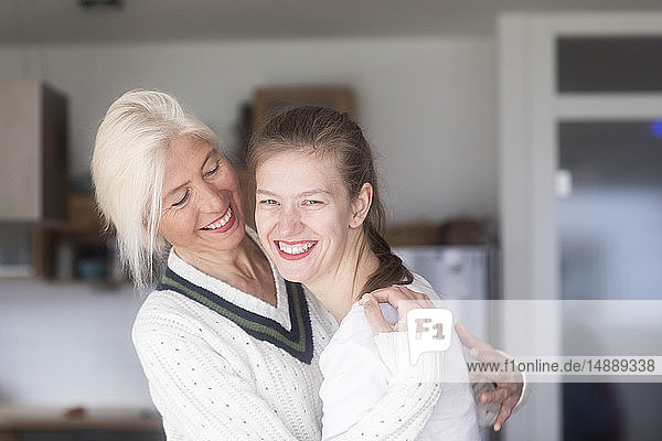 Porträt einer lachenden Mutter  die eine erwachsene Tochter anschaut