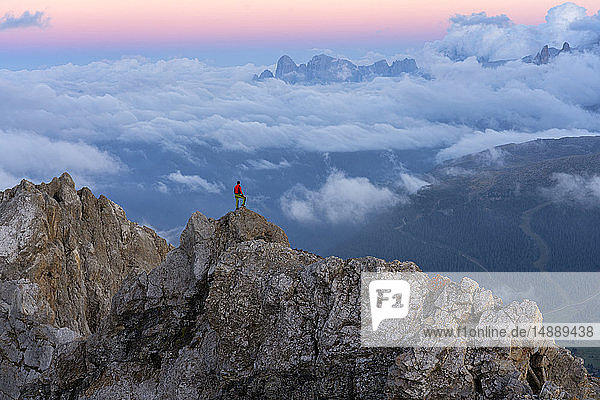 Italien  Venetien  Dolomiten  Alta Via Bepi Zac  Bergsteiger steht bei Sonnenuntergang auf dem Berg Pale di San Martino
