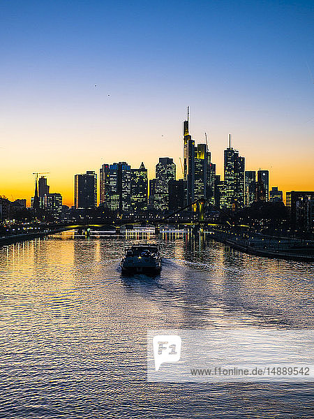 Deutschland  Hessen  Frankfurt  Skyline des Finanzdistrikts  Main und Deutschherrn-Brücke  Frachtschiff bei Sonnenuntergang