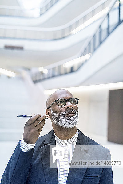 Portrait of mature businessman using smartphone