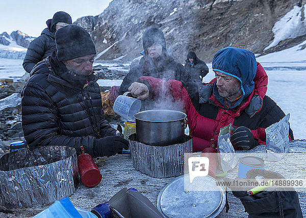 Grönland  Sermersooq  Kulusuk  Schweizerische Alpen  Gruppe von Menschen  die eine Pause machen und Wasser kochen