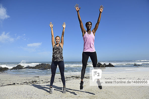 Zwei Frauen machen Fitnessübungen am Strand