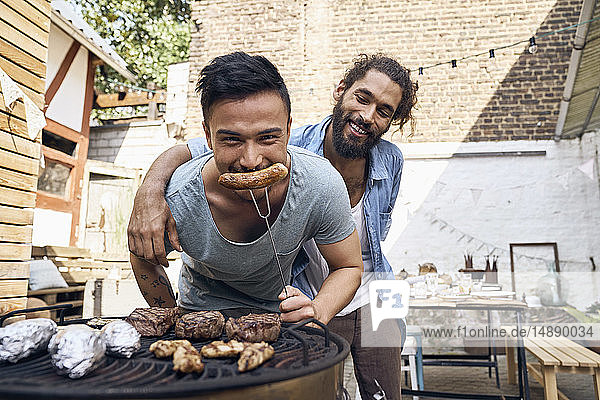 Freunde bereiten Fleisch für ein Barbecue im Hinterhof