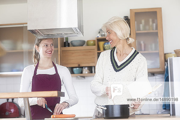 Mutter und erwachsene Tochter kochen gemeinsam zu Hause
