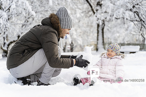 Happy father playing with daughter in winter landscape