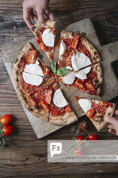 Pizza mit Mozzarella essen  Pizzaschnitt mit der Hand