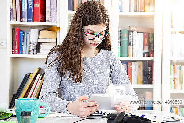 Girl doing homeworks with digital tablet