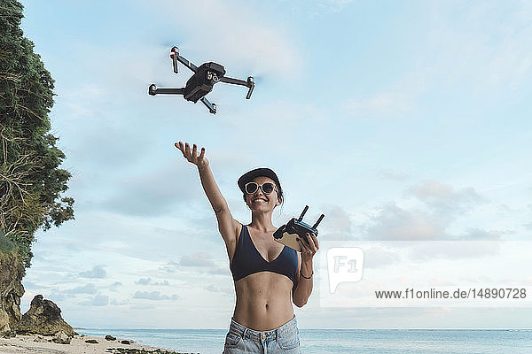 Indonesia  Bali  Nusa Dua  woman flying drone at the beach