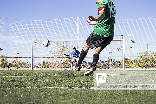 Football player shooting the ball on football field
