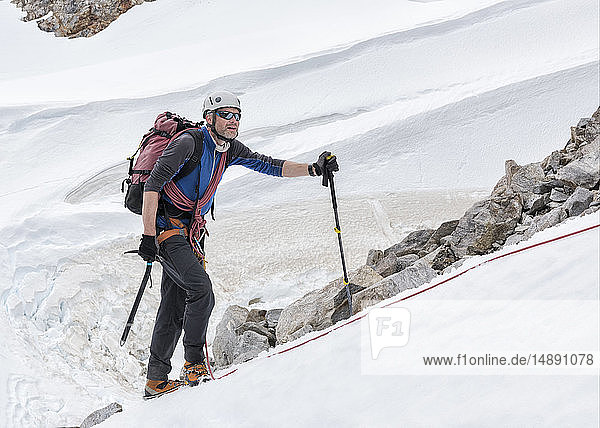 Grönland  Sermersooq  Kulusuk  Schweizer Alpen  Bergsteiger im Schnee aufsteigender Berg