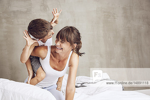 Mutter und Sohn streiten sich im Bett  lachen