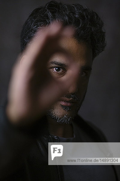 Porträt eines indischen Mannes  der durch die Finger schaut