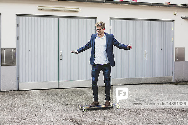 Young businessman riding skateboard at garage door