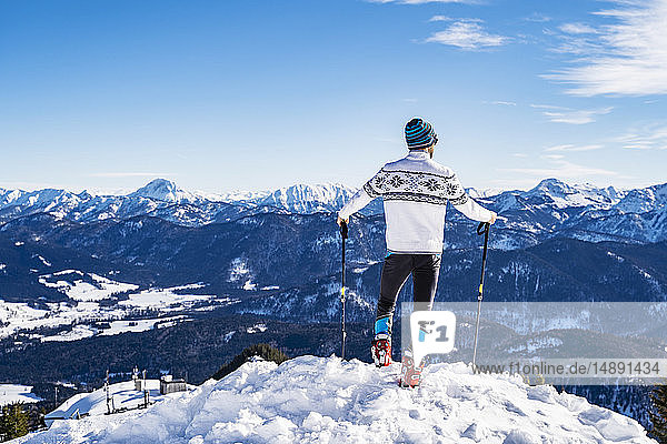 Deutschland  Bayern  Brauneck  Mann im Winter auf Berggipfel stehend
