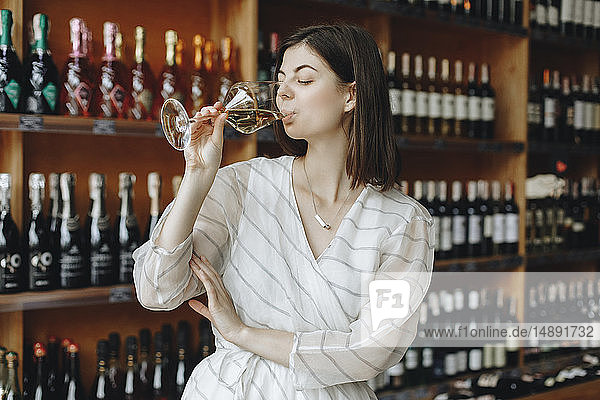 Junge Frau trinkt Weißwein