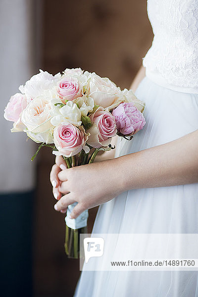 Die Hände der Braut halten den Blumenstrauß