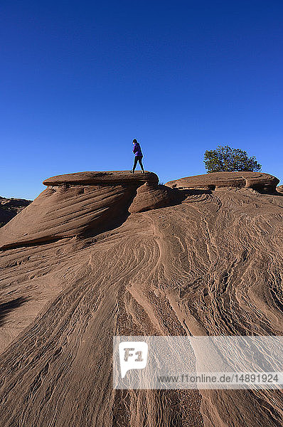 Frau geht auf glatten Felsen im Monument Valley  Arizona  USA