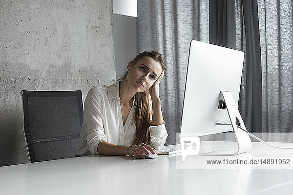 Frustrierte Geschäftsfrau bei der Arbeit am Desktop-Computer