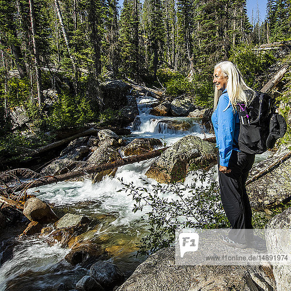 Ältere Frau steht am Fluss im Wald in Stanley  Idaho  USA