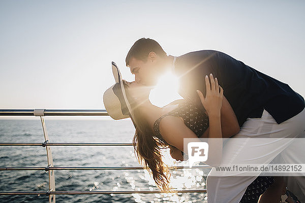 Mann taucht und küsst Frau auf der Seebrücke