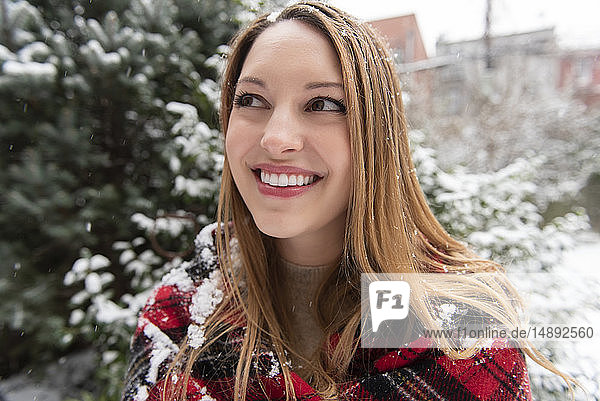 Porträt einer lächelnden jungen Frau im Schnee