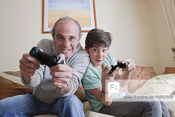 Vater und Sohn im Teenageralter spielen ein Videospiel