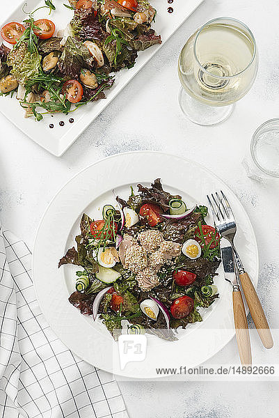 Teller mit Salat und Weißwein