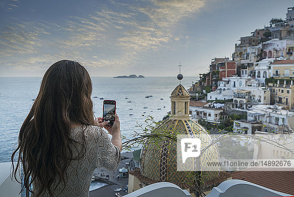 Frau beim Fotografieren mit einem Smartphone in Positano  Italien