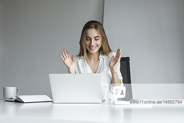 Lächelnde Geschäftsfrau bei der Arbeit am Laptop