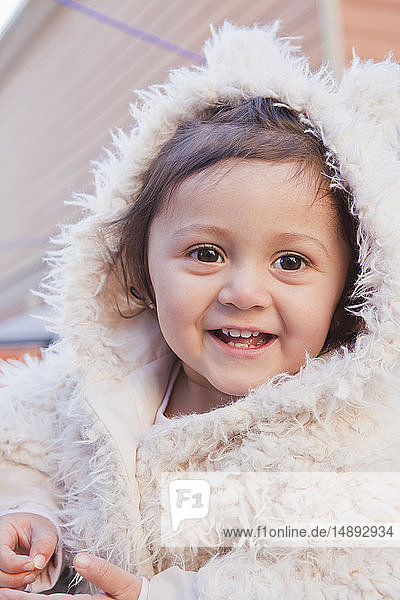Portrait of smiling girl wearing white fur hood