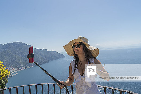 Frau mit Selfie-Stick am Meer