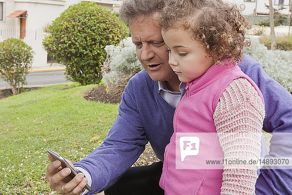 Mann teilt Smartphone mit seiner Tochter