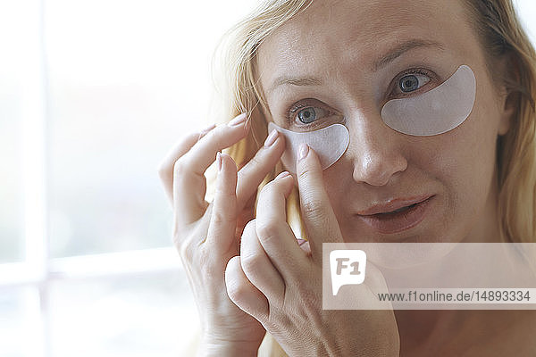 Woman applying under-eye mask