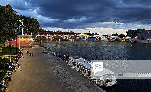Europa; Frankreich; Region Midi-Pyrénées; Departement Okzitanien; Stadt Toulouse; abendlicher Fluss Garonne  Pont Neuf  am Flussufer vertäute Kähne'.