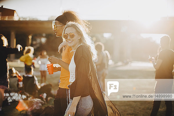 Smiling woman walking with friend at concert
