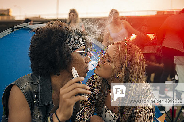 Gemeinsam rauchendes Paar vor dem Zelt bei Musikveranstaltung