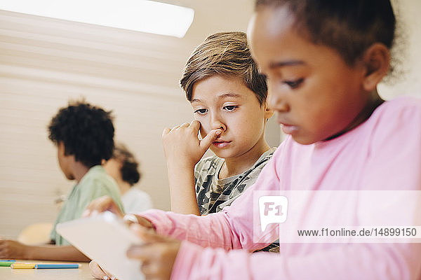 Jungen verwenden digitale Tabletts beim Lernen im Klassenzimmer