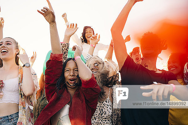 Multi-ethnische fröhliche Fans genießen bei sonnigem Wetter ein Musikkonzert