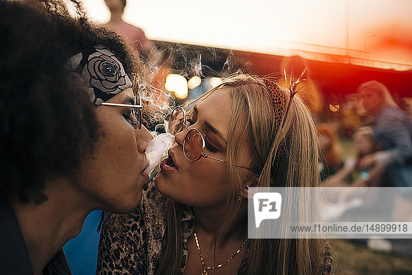 Nahaufnahme eines rauchenden Paares bei einer Musikveranstaltung