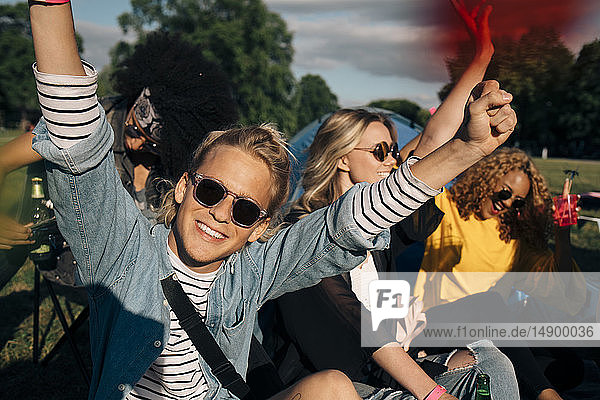 Glücklicher junger Mann genießt mit Freunden beim Musikfestival
