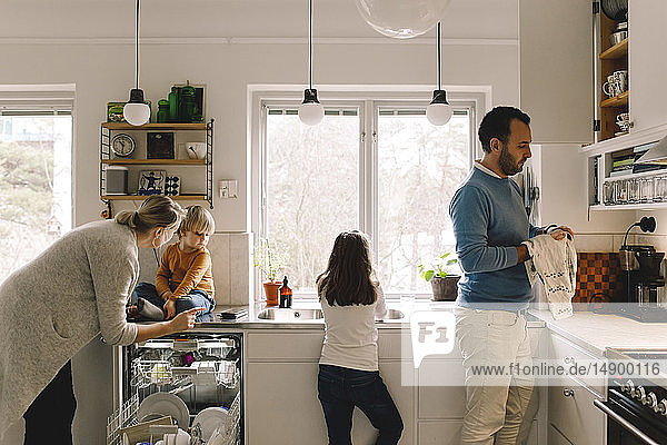 Vierköpfige Familie  die zu Hause in der Küche arbeitet