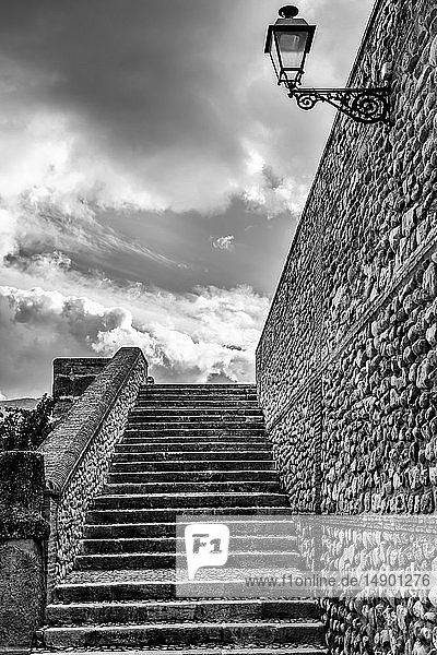 Stufen und eine Steinmauer mit aufgesetztem Licht und bewölktem Himmel; Antequera  Malaga  Spanien