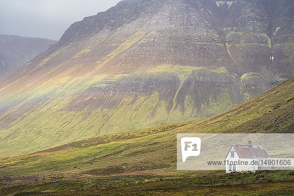 Schwacher Regenbogen über einem verlassenen isländischen Gehöft; Westfjorde  Island