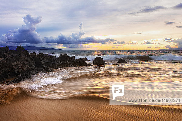 Dramatischer Sonnenuntergang am Strand mit weichem Wasser und Lavafelsen; Makena  Maui  Hawaii  Vereinigte Staaten von Amerika