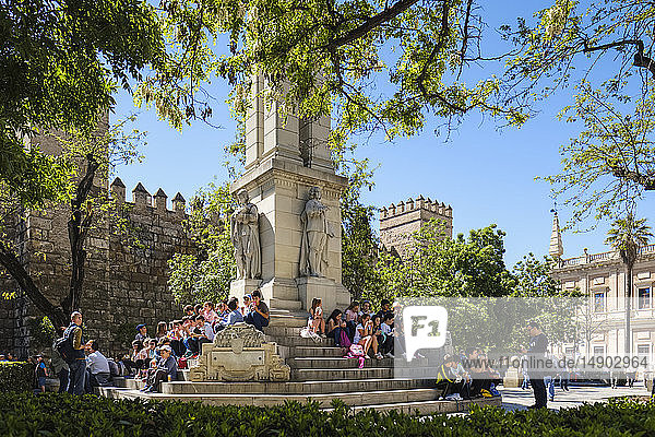 Schulkinder in der Mittagspause  Denkmal der Unbefleckten Empfängnis  Plaza del Triunfo  Real Alcazar im Hintergrund; Sevilla  Andalusien  Spanien