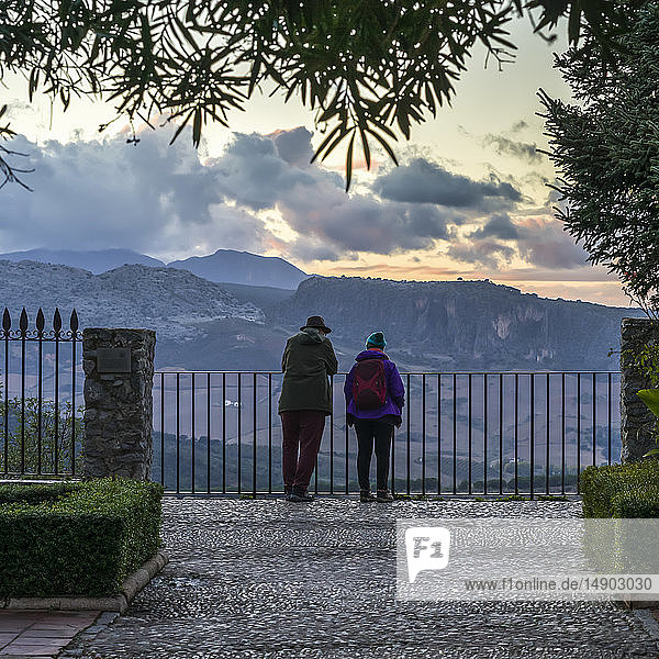 Ein älteres Paar steht an einem Zaun und blickt auf die Landschaft von Ronda bei Sonnenuntergang; Ronda  Provinz Malaga  Spanien