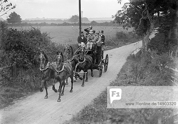 Glasnegativ um 1900.Viktorianisch.Sozialgeschichte. Pferd  Kutsche und Menschen  die an einer Fuchsjagd teilnehmen  reiten eine Landstraße entlang. Es wird ein Horn geblasen.
